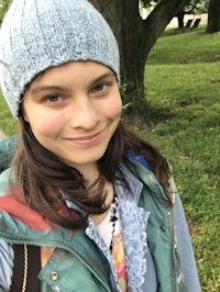 a young girl wearing a blue hat and scarf