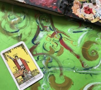 a painting of a tarot card on a green canvas